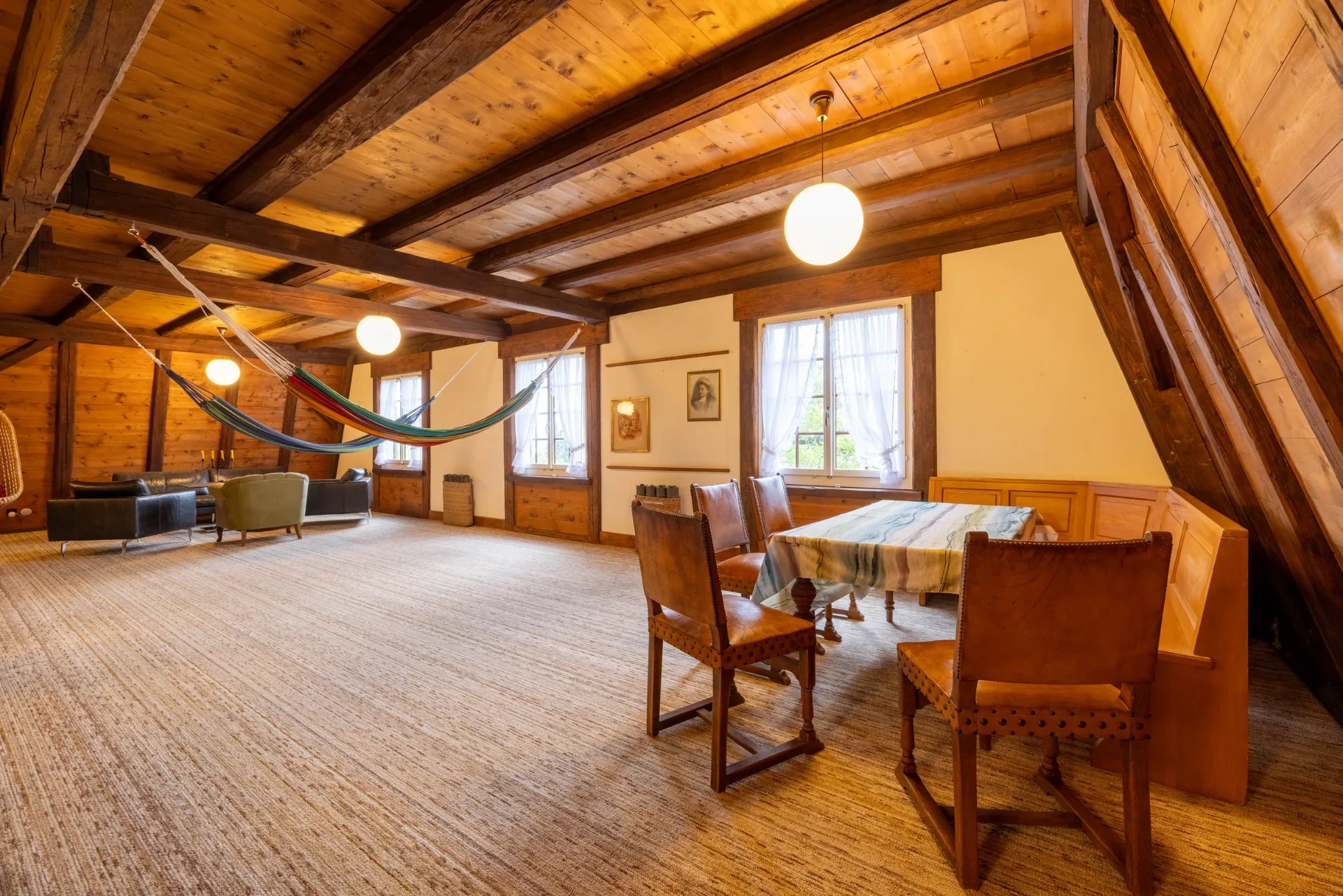 Gemütliche Sitzecke mit Hängematten und Holztisch im Spielezimmer