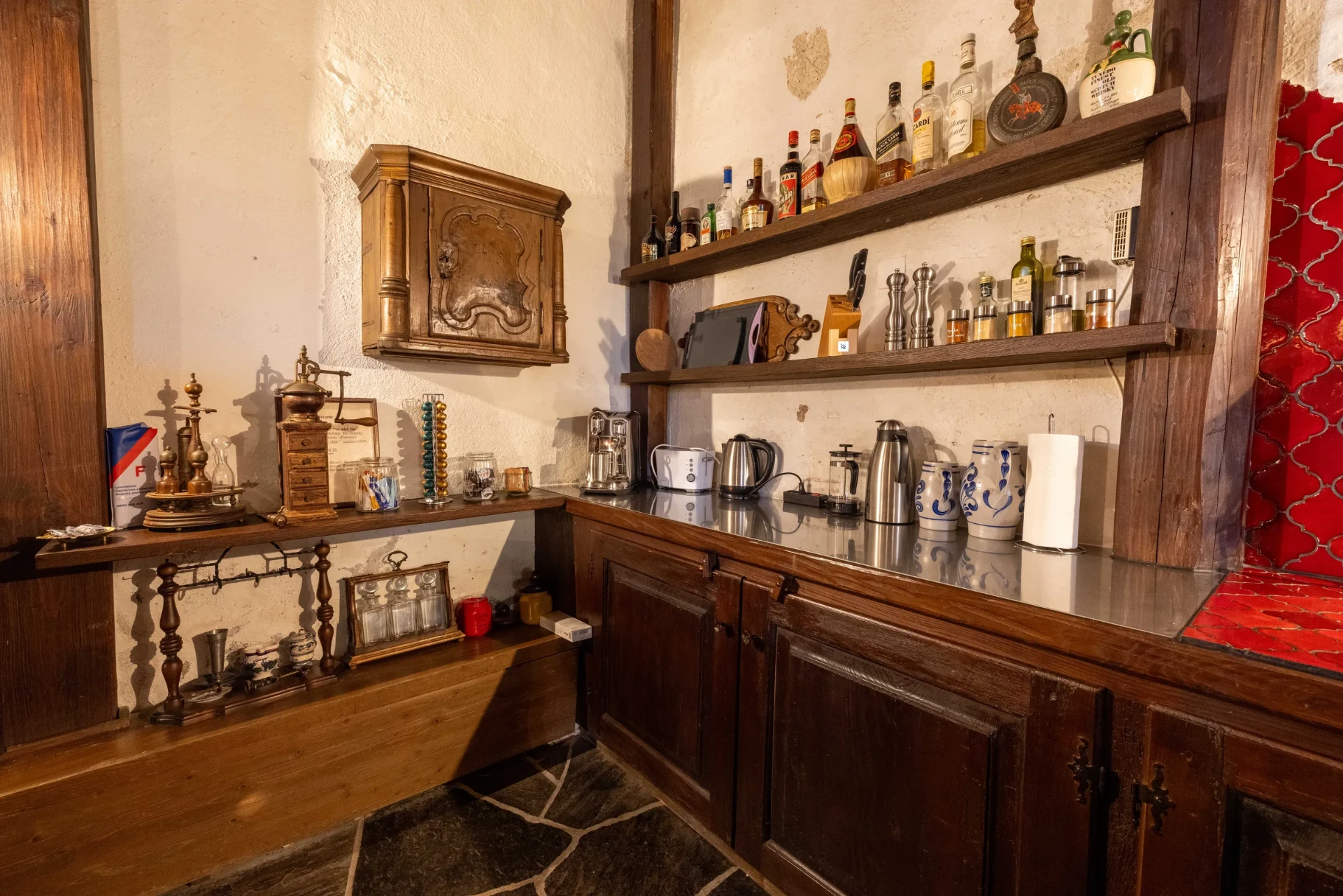 Küchendetail im Event-Keller: historische Hängeschränke, Kaffeemühle und Gewürzregale