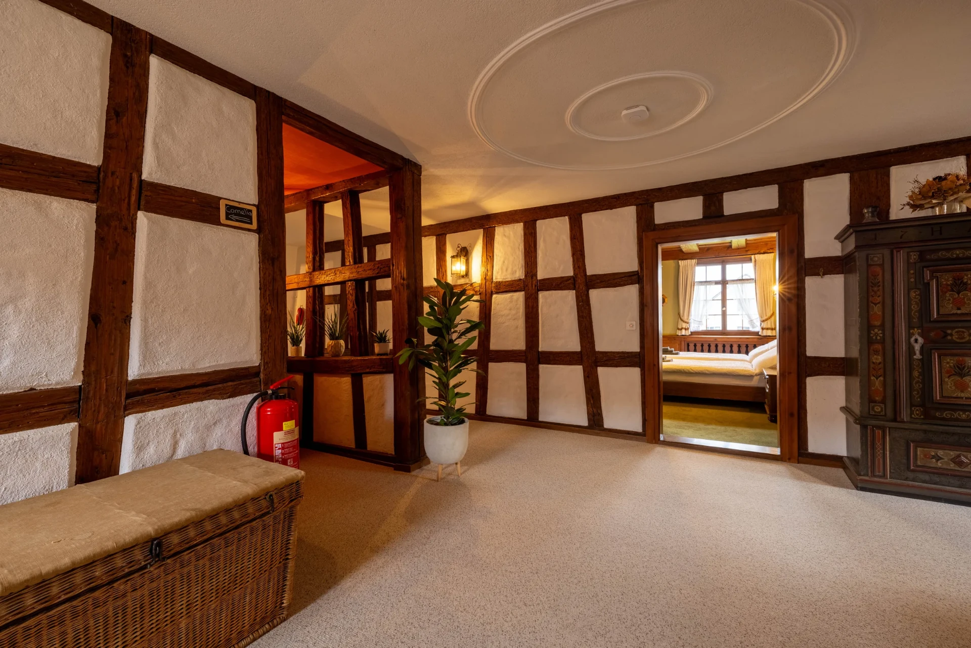 Vorraum mit Fachwerk, Weidentruhe und Blick in das Zimmer „Camelia“