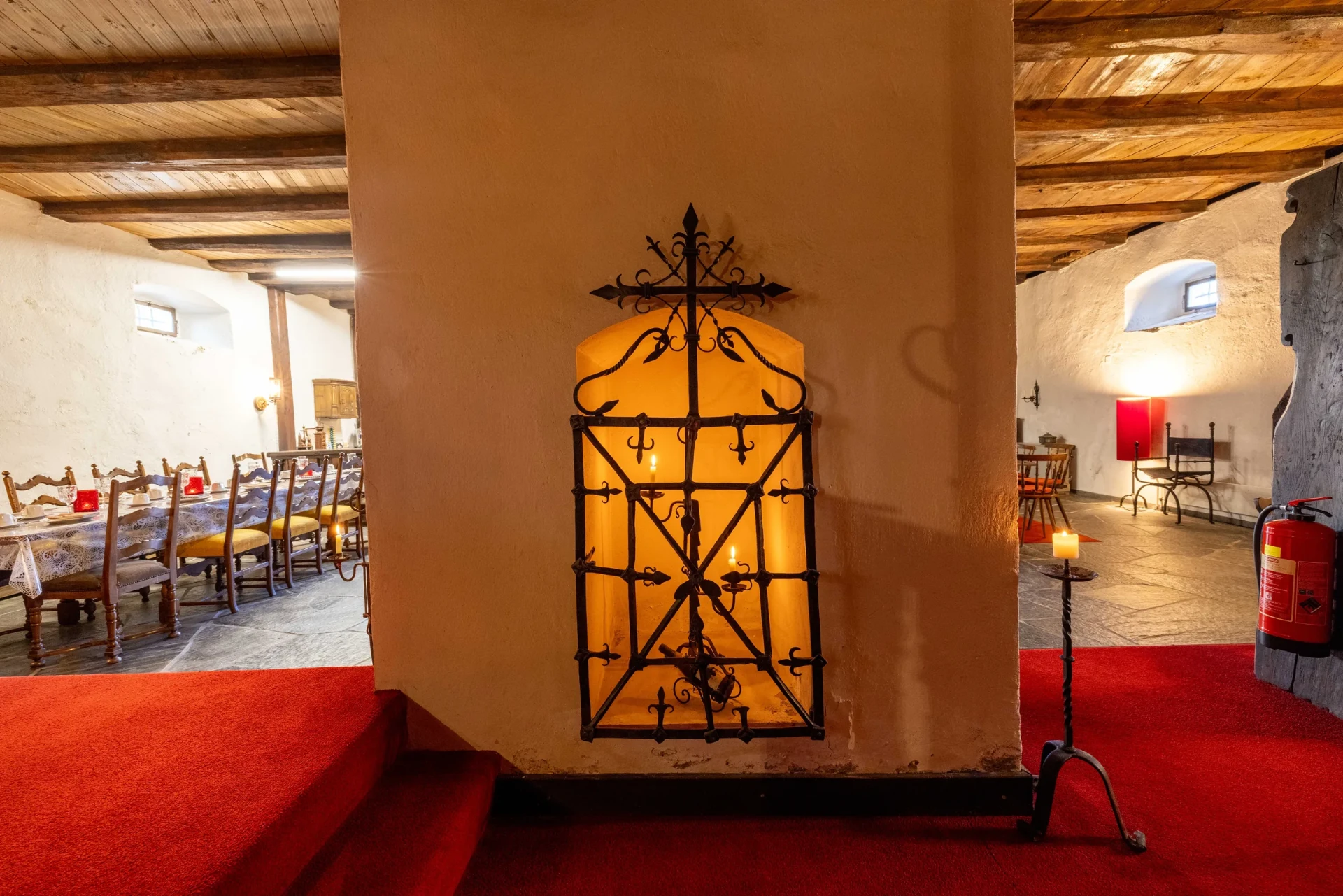 Schmiedeeisernes Ziertor mit Kerzen zwischen Essbereich und Gang im Event-Keller