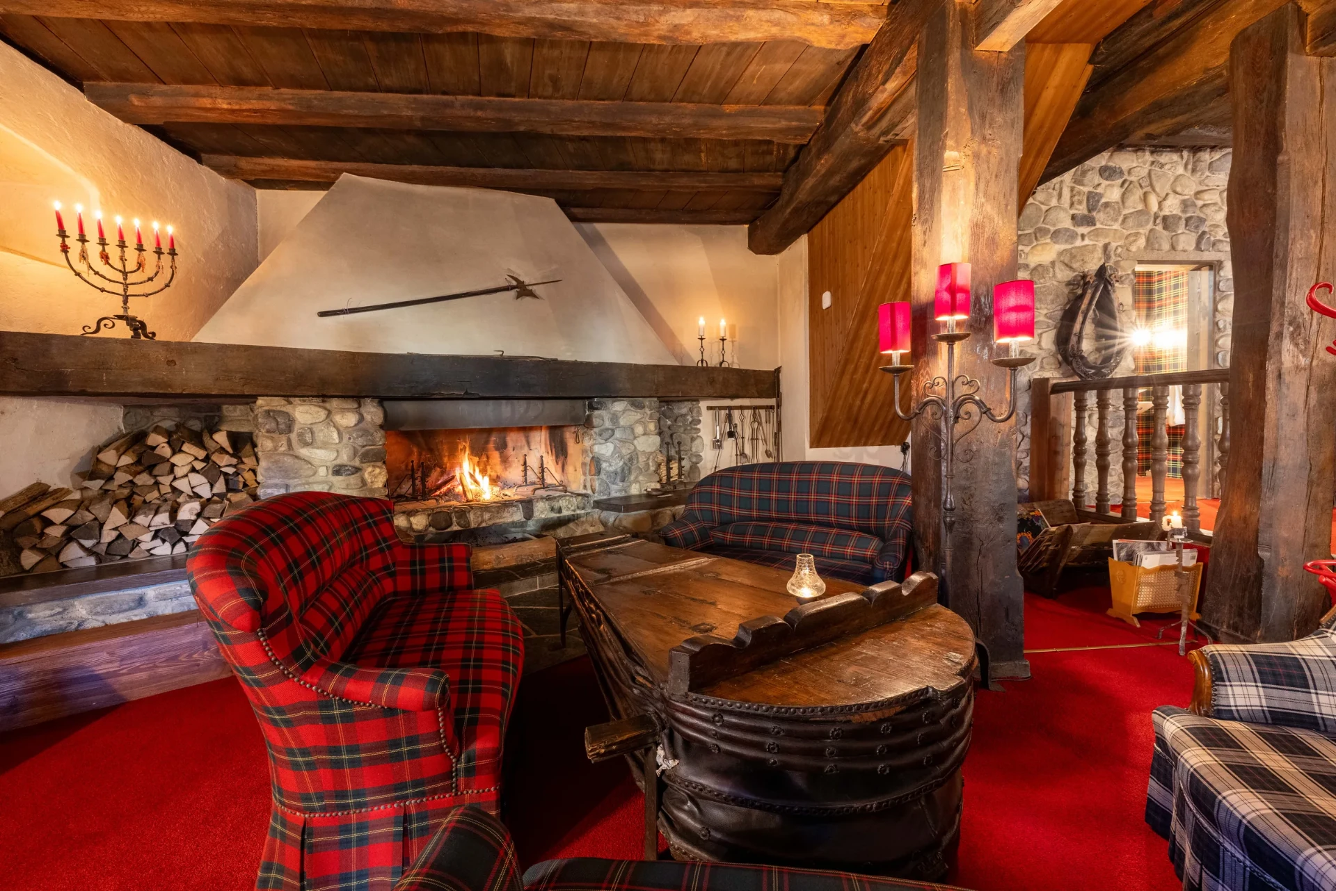 Cheminée im Event-Keller mit Naturstein, Holzvorrat und historischem Balkenwerk